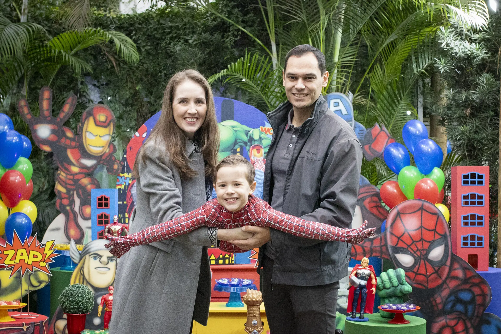 Família reunida em festa de aniversário infantil com tema de super-heróis