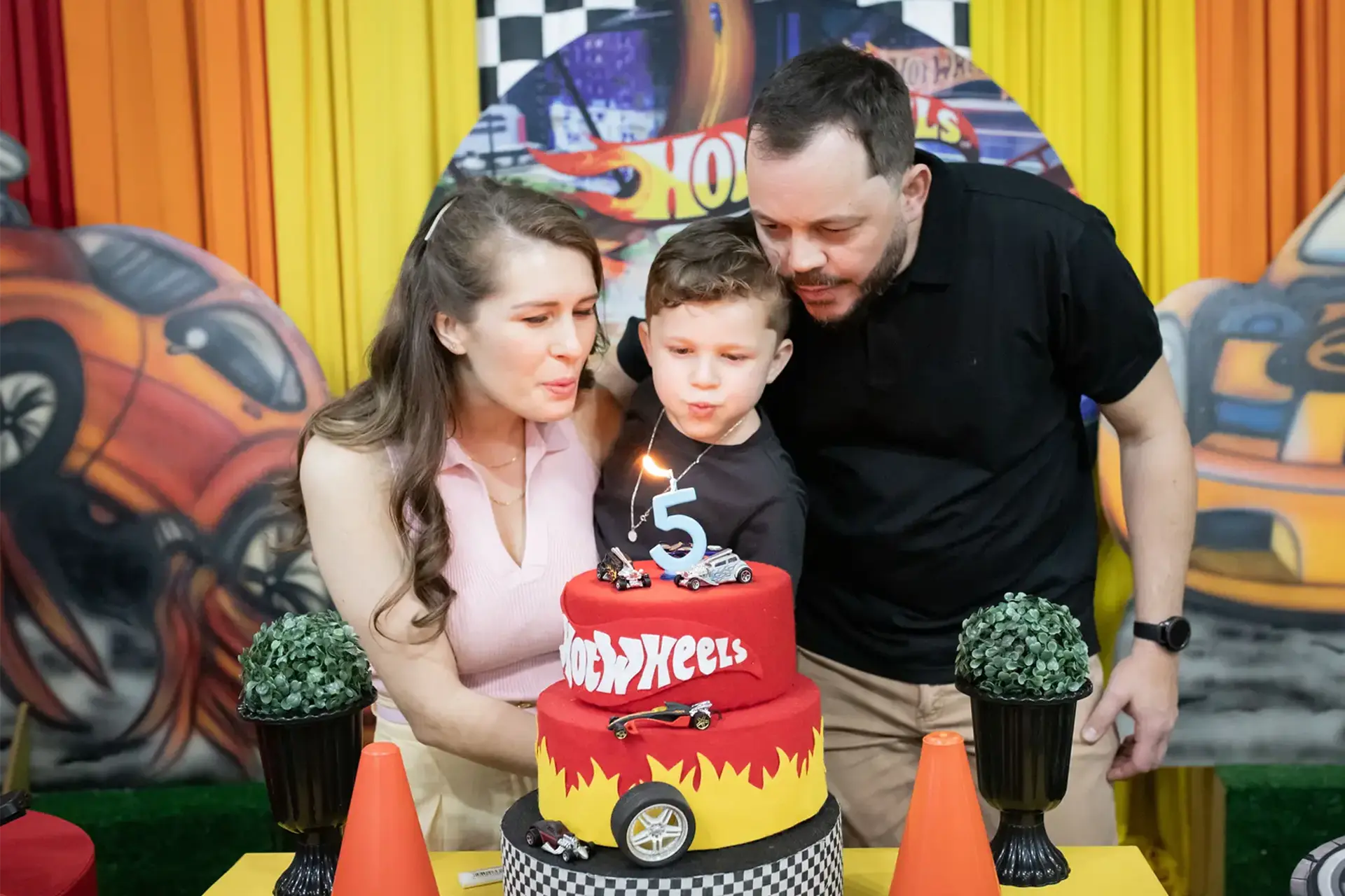Família comemorando aniversário infantil ao redor do bolo